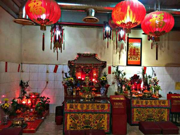 Cette photo montre l'intérieur de l'Autel. On y voit des divinités, des lampions asiatiques rouges pendent du plafond.